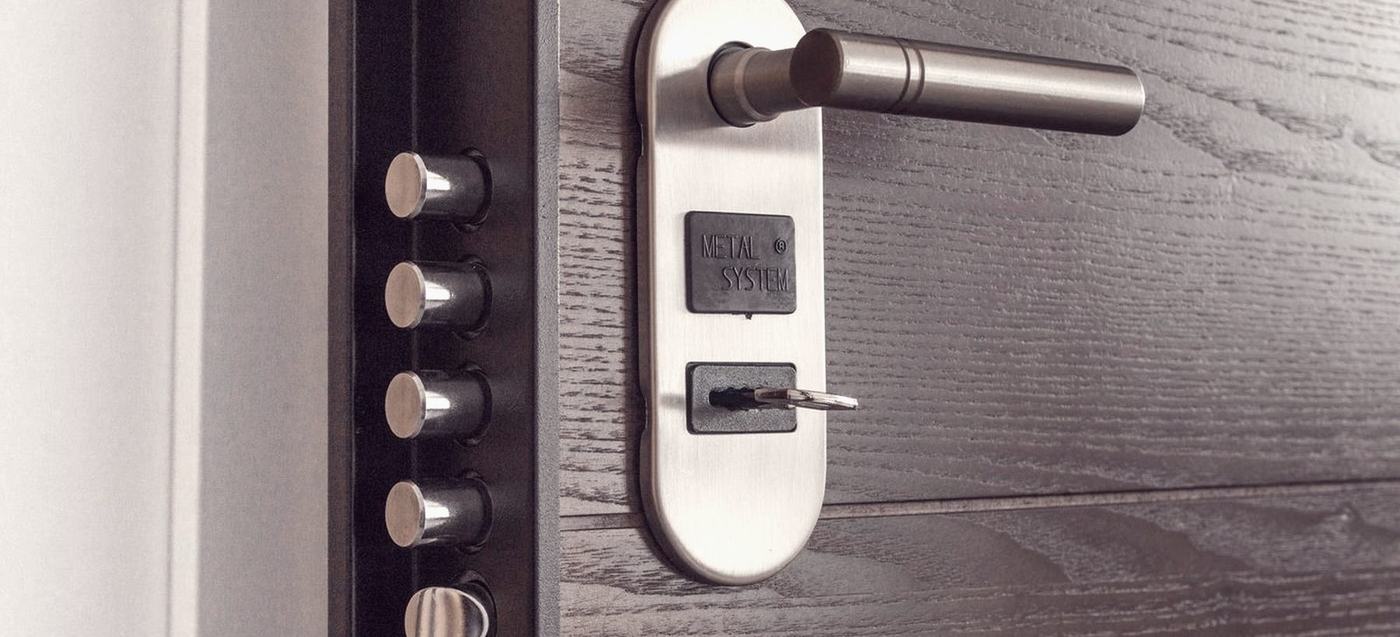A keypad smart lock fitted to a front door, photographed from outside.